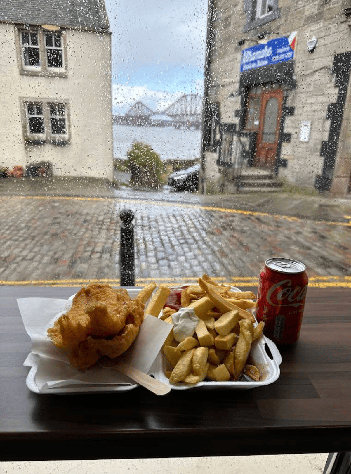 Maurizio’s SQ crispy fish & chips and a can of Coca-Cola with a view of the Forth Bridge.
